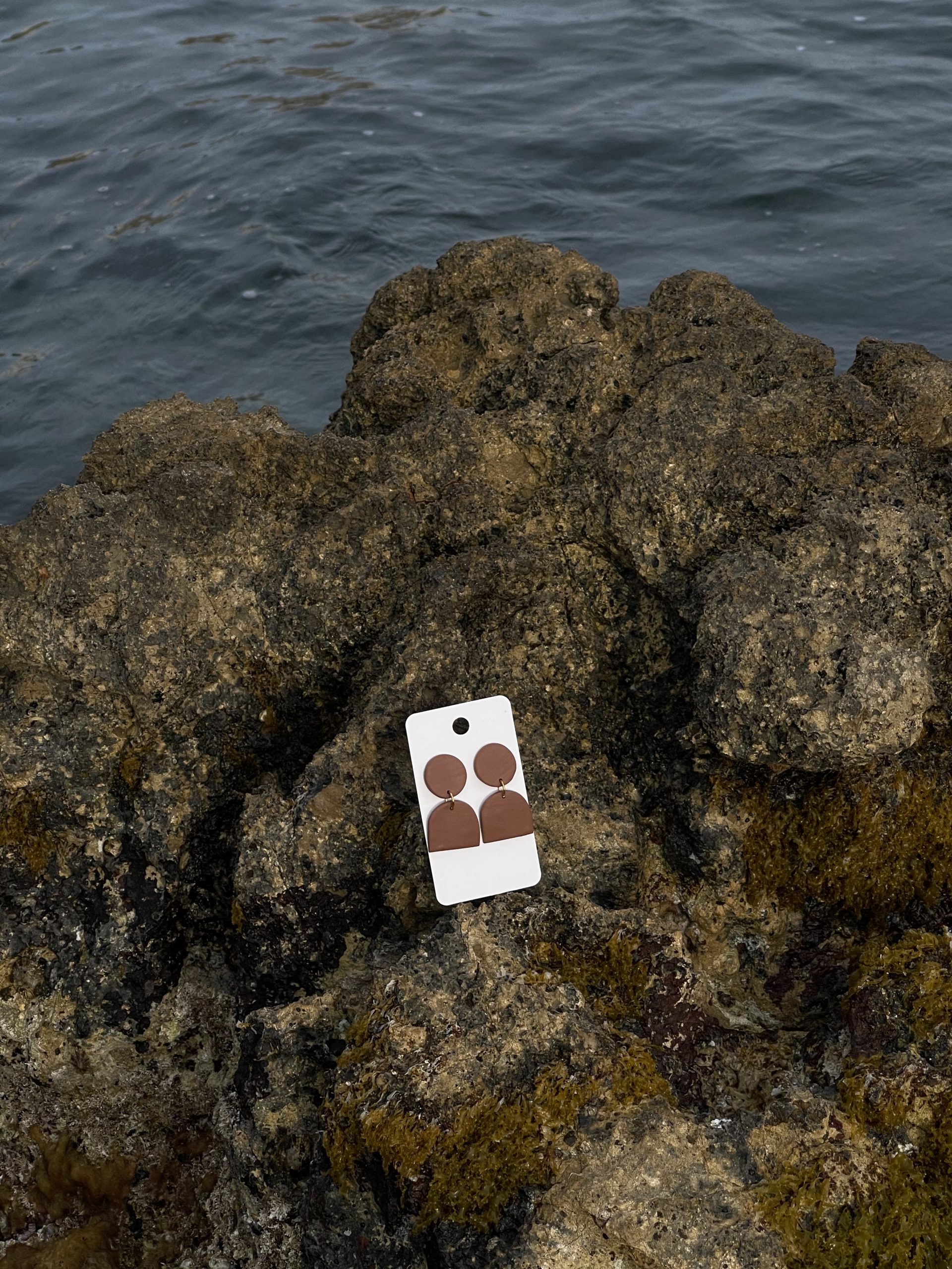 close up - zoom - gros plan de mes créations - home made - boucles d'oreilles mi-longues marrons - cercles & demi-cercle - sur un rocher au bord de la mer