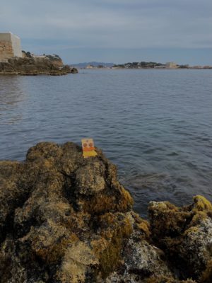 photo dézoomer - centrée sur mes créations - boucles d'oreilles longues marrons, orange & moutarde - cercles & demi-cercle - sur un rocher au bord de la mer