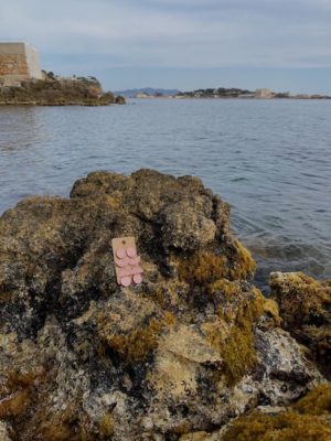 photo dézoomer - centrée sur mes créations - boucles d'oreilles pendentes rose paillettes - longues - cercles & demi-cercle - rose gold - sur un rocher au bord de la mer